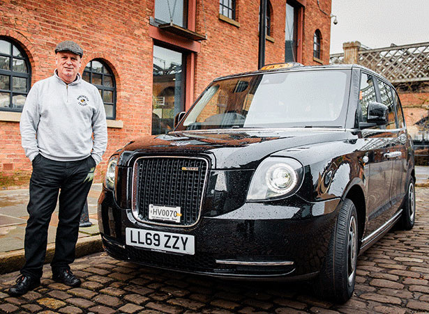 john consterdine standing with his electric black cab